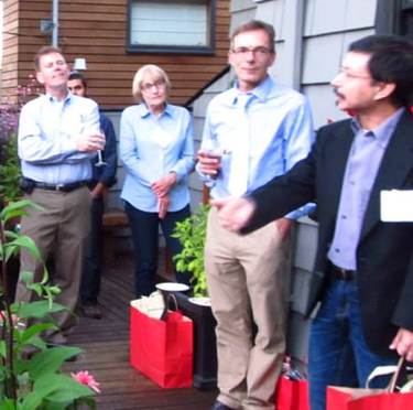 CSUEB alumni standing in a group in an outside garden.